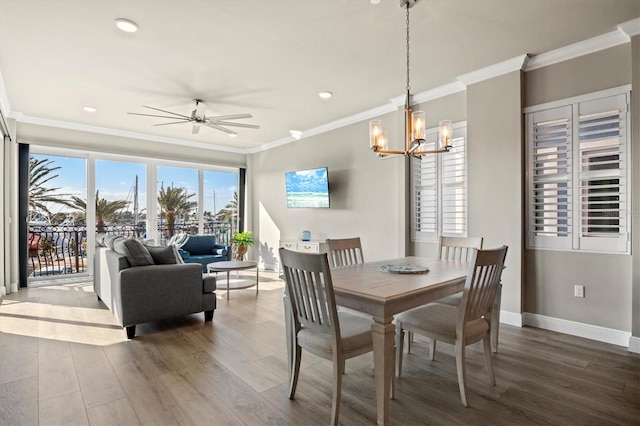 dining space with ornamental molding, hardwood / wood-style floors, and ceiling fan with notable chandelier