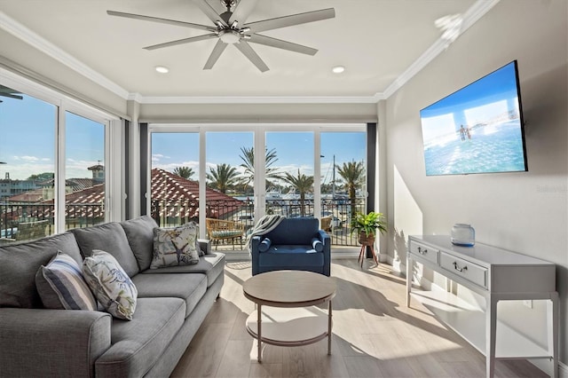 living room featuring light wood-type flooring, ceiling fan, and ornamental molding