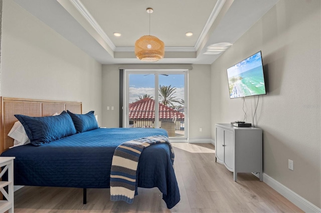 bedroom with access to outside, light hardwood / wood-style floors, a raised ceiling, and crown molding