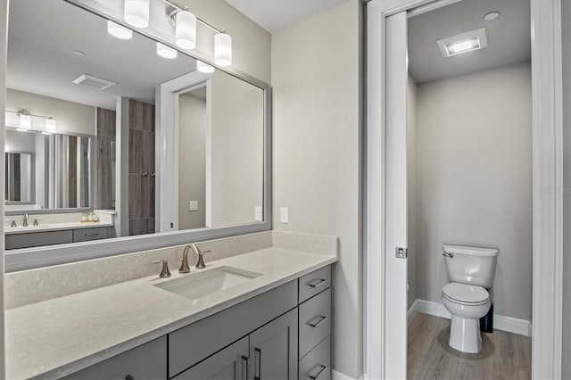 bathroom with wood-type flooring, toilet, and vanity