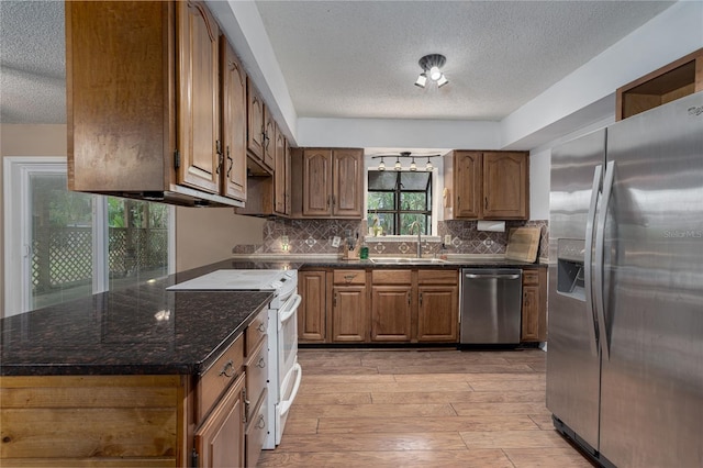 kitchen featuring light hardwood / wood-style flooring, stainless steel appliances, a textured ceiling, and sink