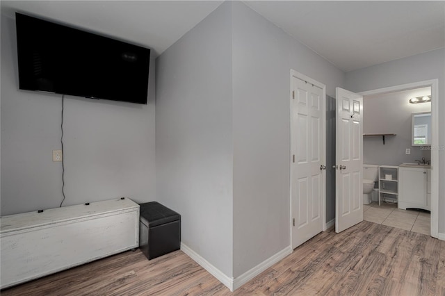 hallway with light hardwood / wood-style flooring and sink