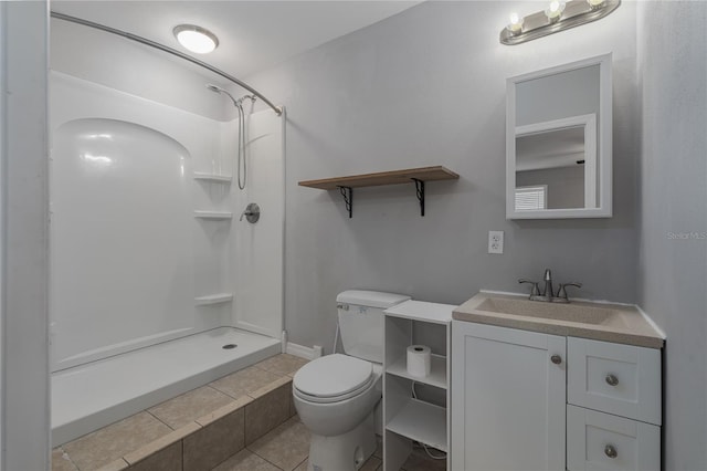 bathroom featuring a shower, vanity, tile patterned flooring, and toilet