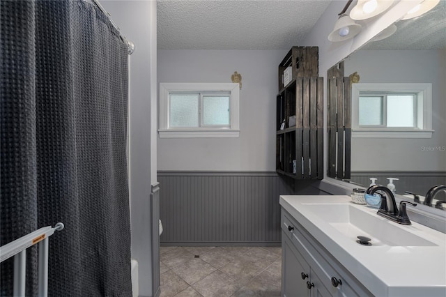 bathroom with a shower with shower curtain, vanity, tile patterned flooring, and a textured ceiling