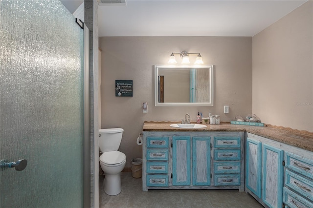 bathroom with vanity, tile patterned floors, a shower with door, and toilet