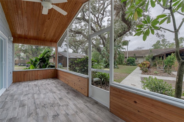 unfurnished sunroom with ceiling fan, lofted ceiling, and wood ceiling