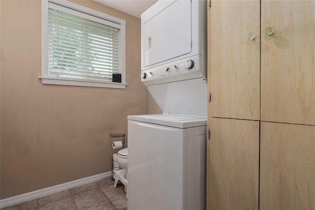 washroom with stacked washer and dryer and light tile patterned floors