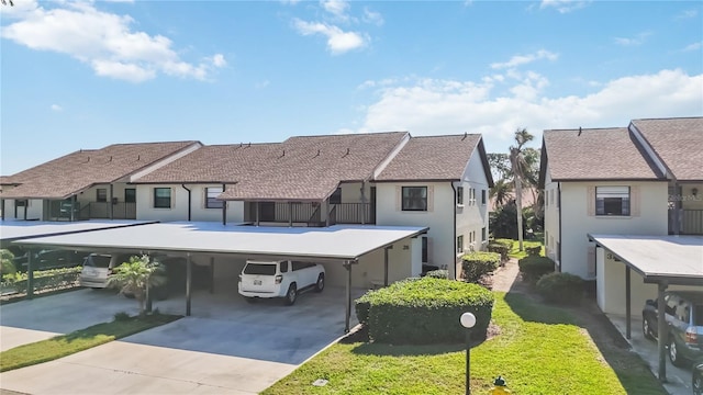 exterior space with stucco siding, a residential view, a carport, and concrete driveway