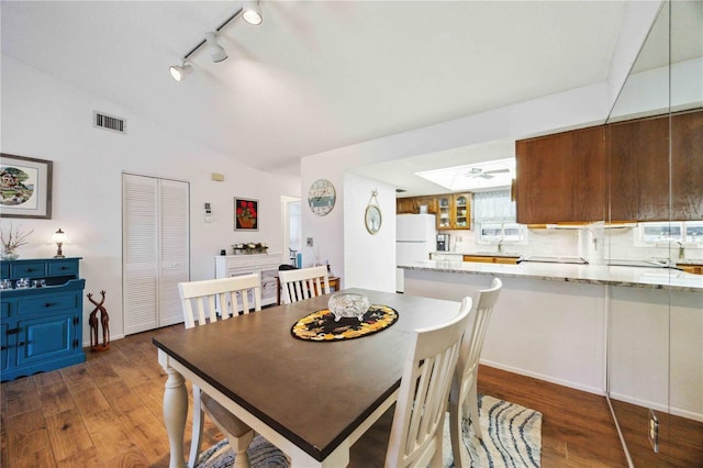 dining room with lofted ceiling, wood finished floors, and visible vents