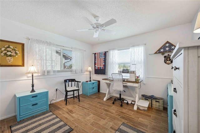 office space with baseboards, ceiling fan, a textured ceiling, and wood finish floors