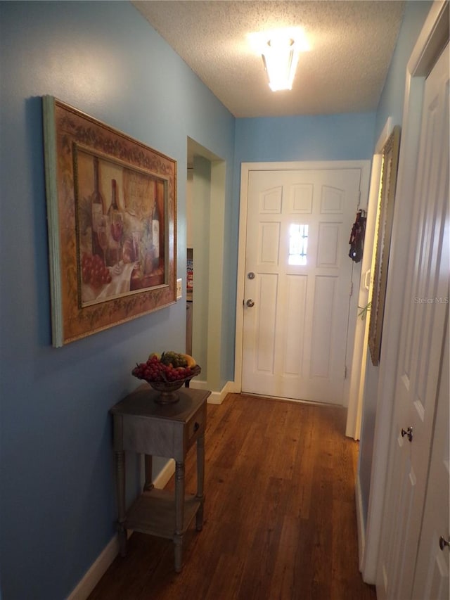 entryway featuring a textured ceiling and dark wood-type flooring