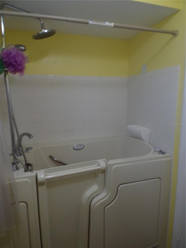 bathroom with a bathing tub and washer / clothes dryer