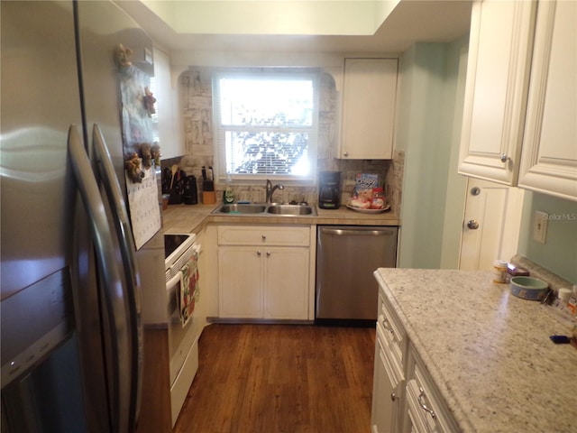 kitchen with light stone countertops, stainless steel appliances, sink, white cabinets, and dark hardwood / wood-style floors