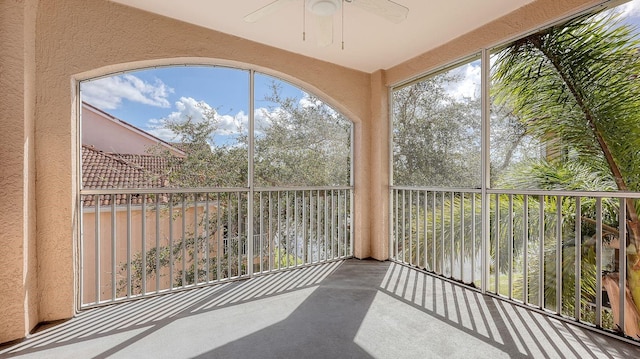 unfurnished sunroom featuring ceiling fan