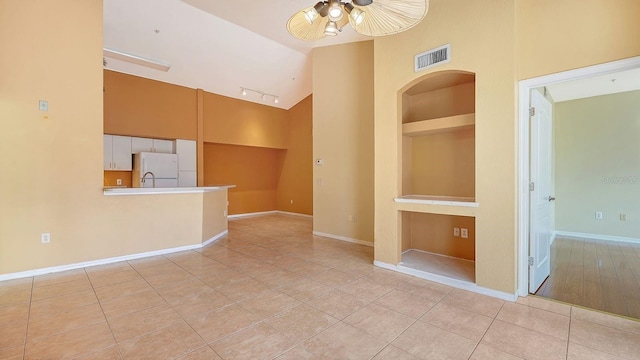 4134 Central Sarasota Pkwy Unit 1734, Sarasota, FL 34238 - empty room with a ceiling fan, high vaulted ceiling, light tile patterned floors, baseboards, and rail lighting