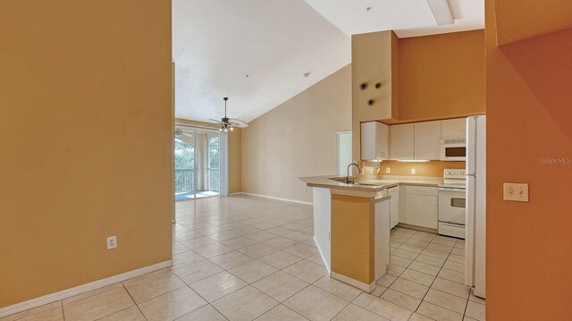 4134 Central Sarasota Pkwy Unit 1734, Sarasota, FL 34238 - kitchen with a peninsula, white appliances, light tile patterned floors, high vaulted ceiling, and baseboards