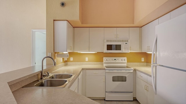 kitchen featuring light tile patterned floors, white appliances, white cabinetry, and sink