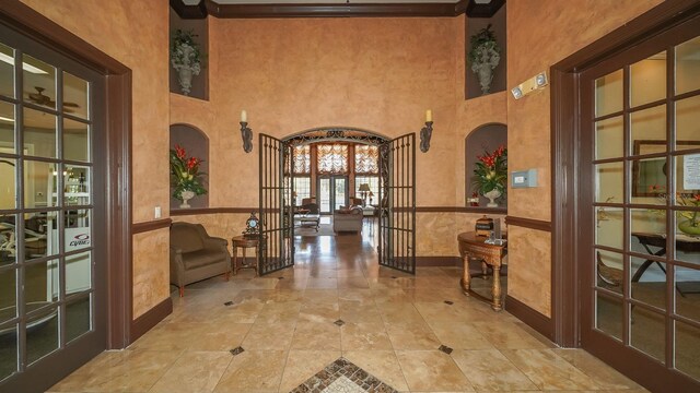 4134 Central Sarasota Pkwy Unit 1734, Sarasota, FL 34238 - hall with arched walkways, french doors, a wainscoted wall, a high ceiling, and baseboards