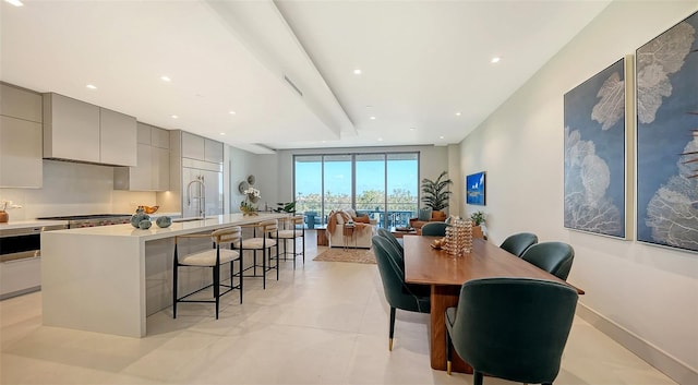 dining area featuring sink and light tile patterned flooring