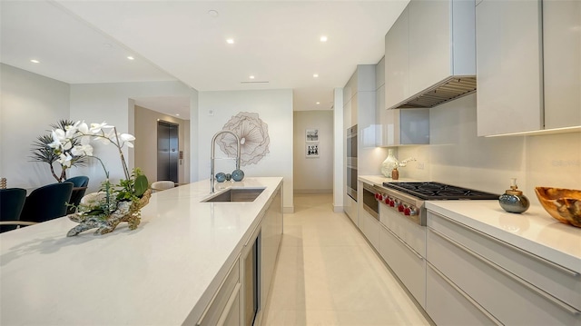 kitchen featuring stainless steel gas cooktop, sink, premium range hood, and light tile patterned flooring