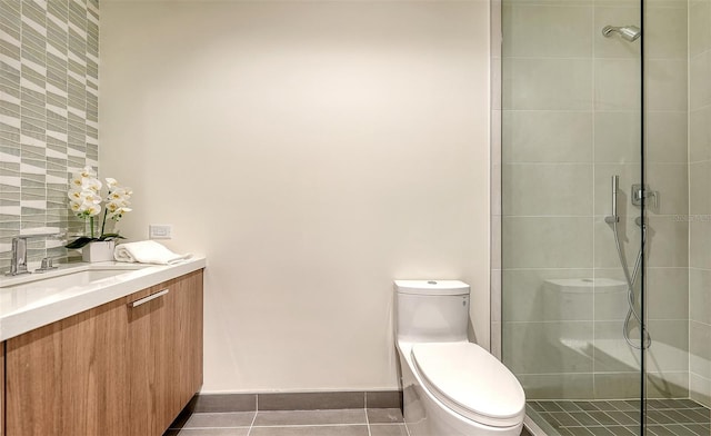 bathroom with vanity, walk in shower, tile patterned flooring, and toilet