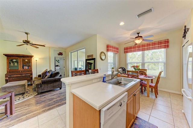 kitchen with ceiling fan, sink, white appliances, a center island with sink, and light wood-type flooring