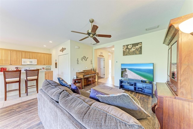 living room featuring hardwood / wood-style floors and ceiling fan