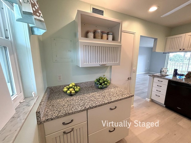 kitchen with white cabinets, dishwasher, light wood-type flooring, and light stone counters