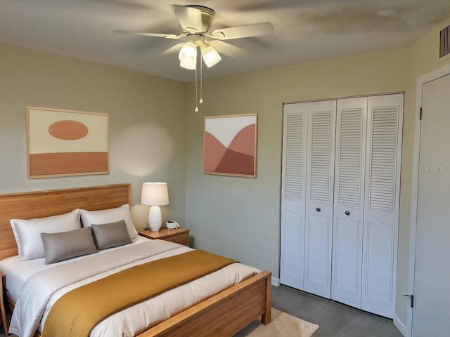 bedroom with a closet, wood-type flooring, and ceiling fan