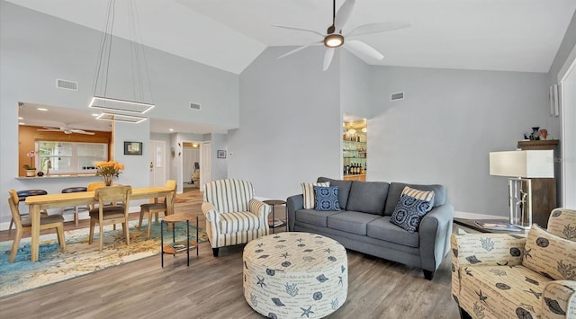 living room featuring hardwood / wood-style floors, high vaulted ceiling, and ceiling fan