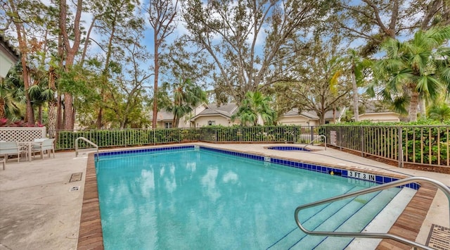 view of swimming pool featuring a patio and a hot tub