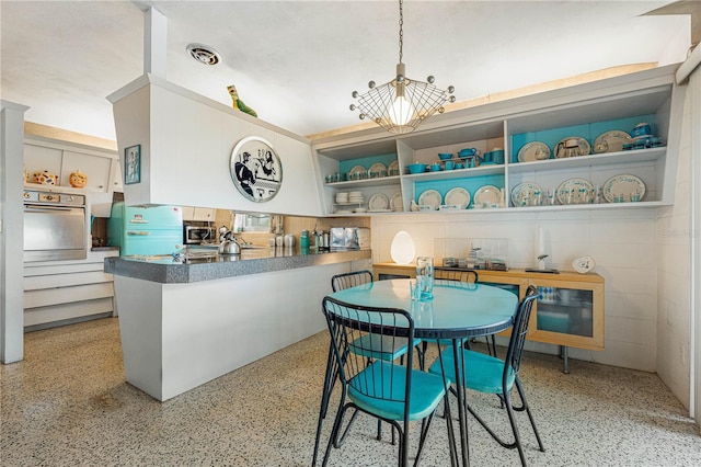 kitchen with kitchen peninsula, hanging light fixtures, and stainless steel appliances