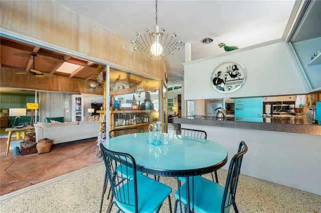 dining area with ceiling fan with notable chandelier and vaulted ceiling