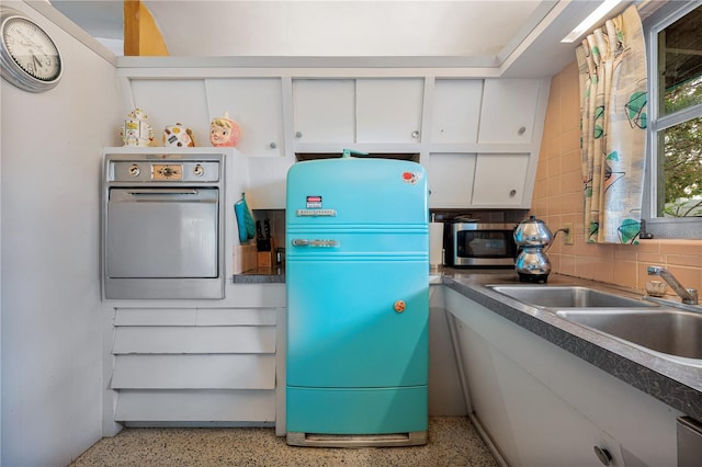 kitchen with white cabinetry, sink, and backsplash