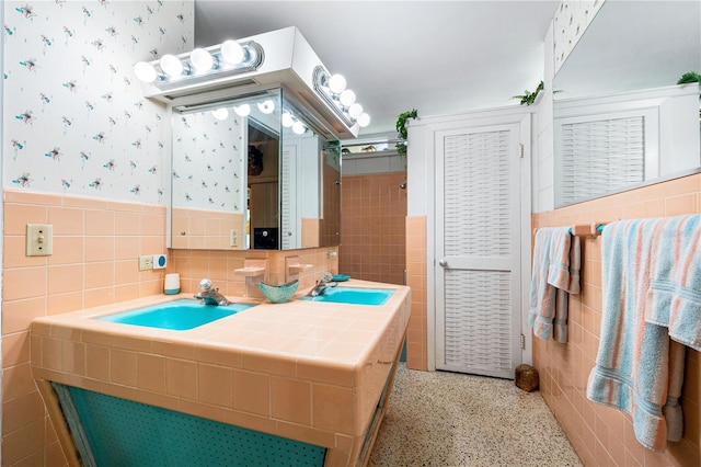 bathroom featuring vanity and tile walls