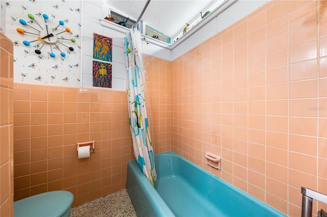 bathroom featuring shower / bath combo, tile walls, and toilet