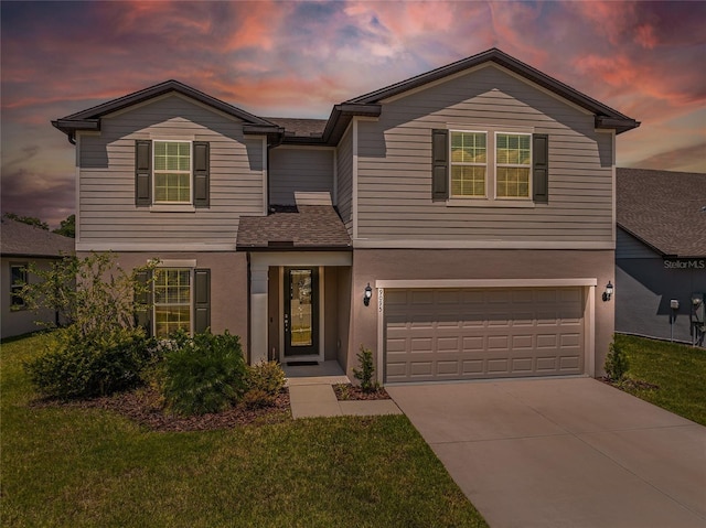 view of front of home with a garage and a lawn