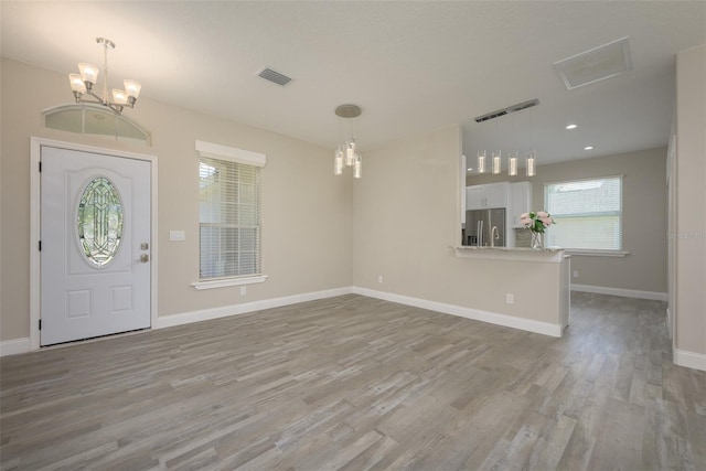 entrance foyer featuring an inviting chandelier and light wood-type flooring