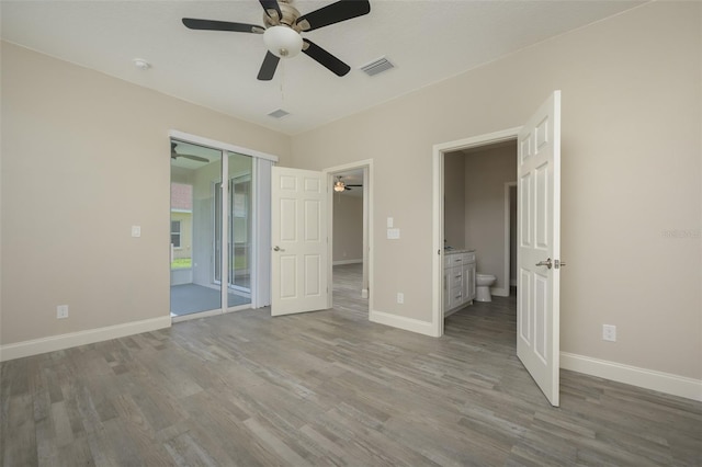 unfurnished bedroom with a closet, hardwood / wood-style flooring, ceiling fan, and ensuite bath