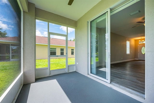 unfurnished sunroom featuring ceiling fan