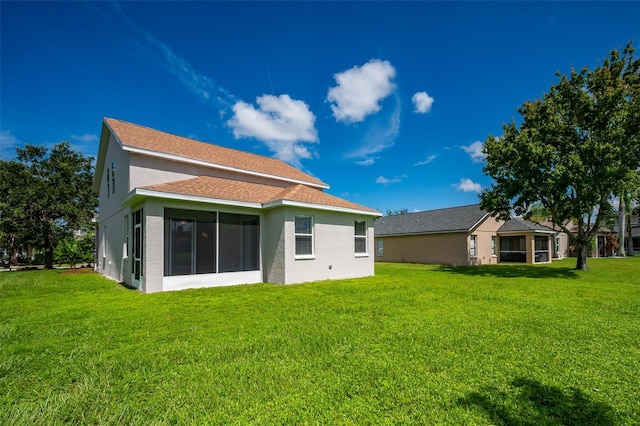 back of house with a sunroom and a yard