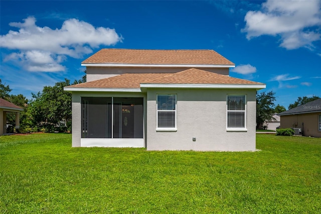 back of house featuring a lawn and a sunroom