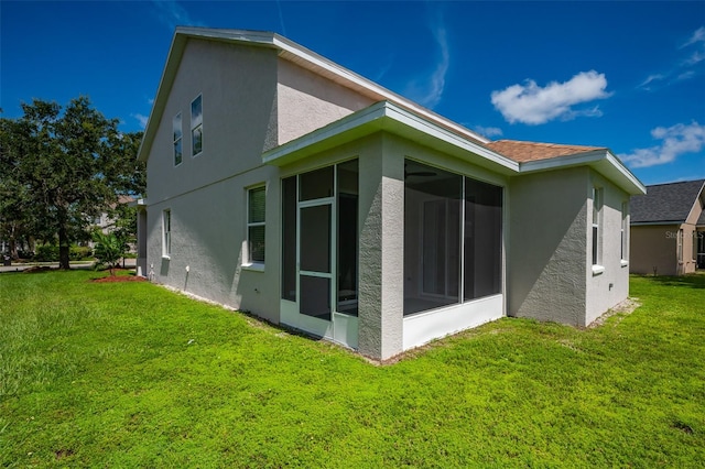 view of side of home featuring a sunroom and a yard