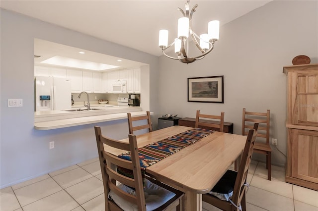 tiled dining room featuring a chandelier, sink, and a raised ceiling