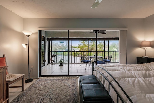 bedroom featuring access to outside, light tile patterned floors, and ceiling fan