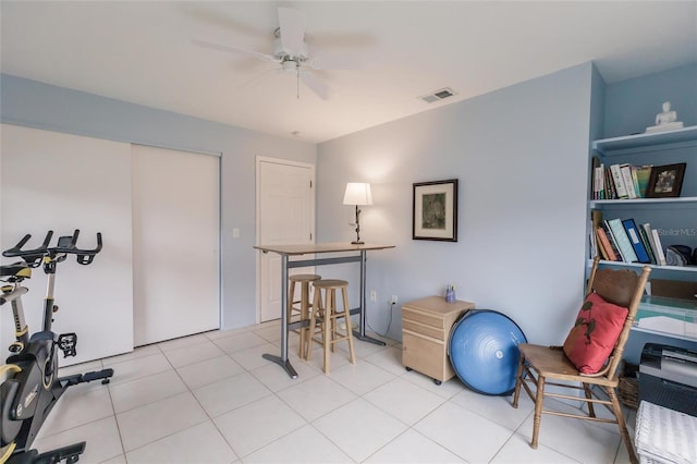 workout area with ceiling fan and light tile patterned flooring