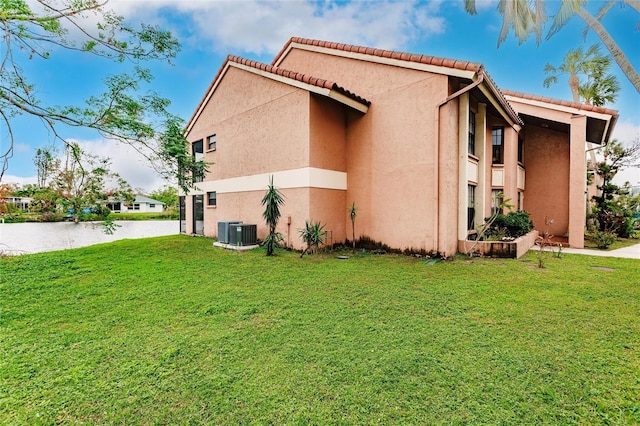 view of home's exterior with central AC and a lawn