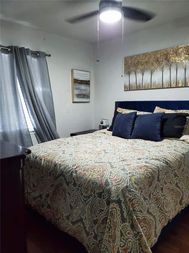 bedroom with dark hardwood / wood-style flooring and ceiling fan