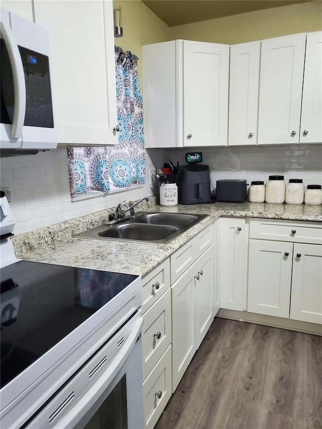 kitchen with white cabinetry, sink, dark wood-type flooring, white appliances, and decorative backsplash