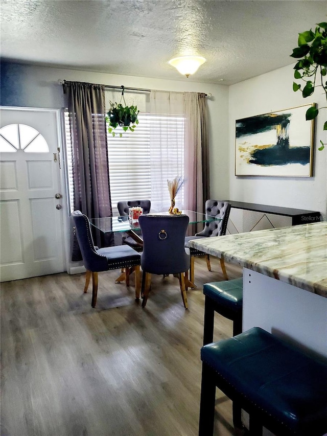 dining room with hardwood / wood-style flooring and a textured ceiling